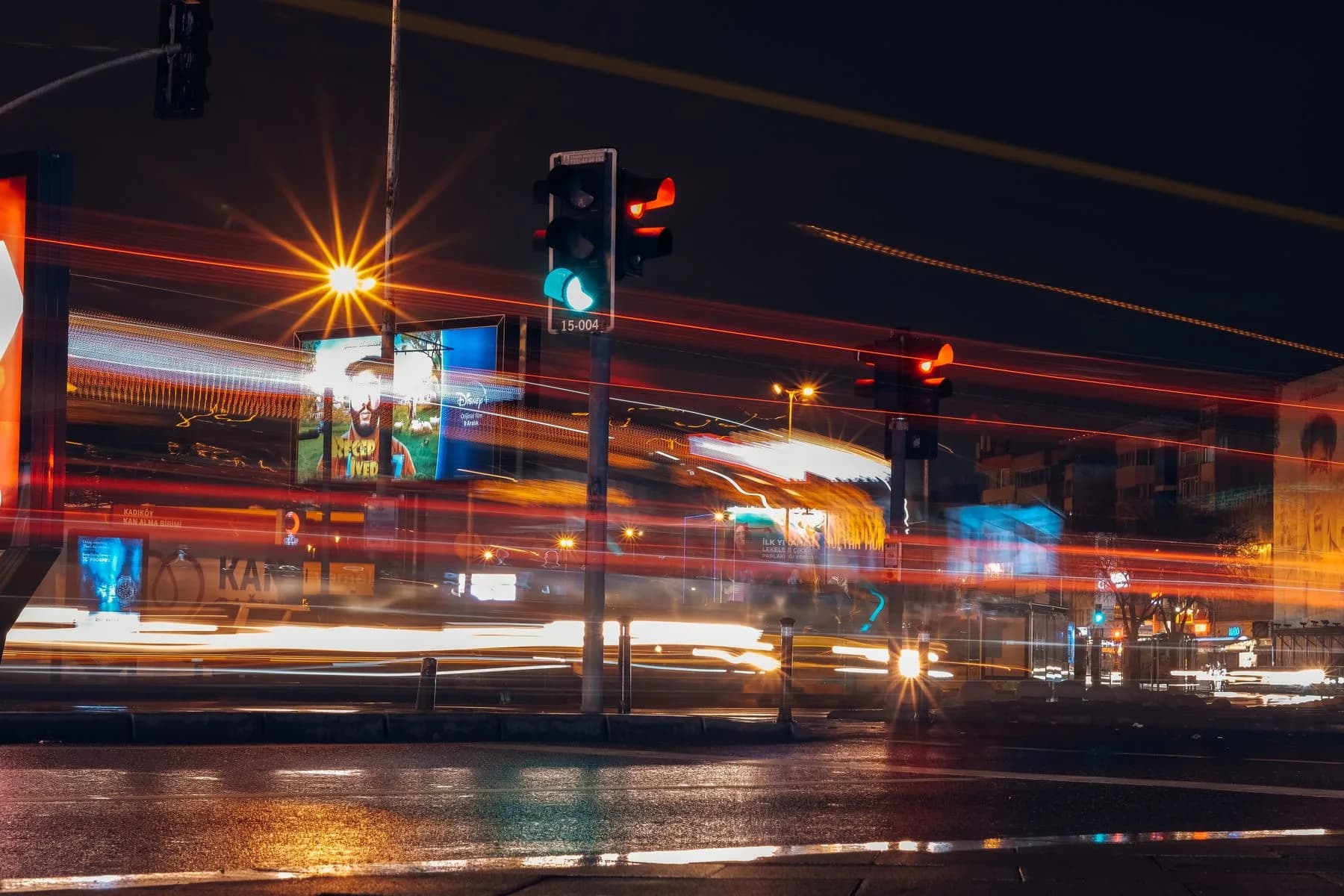 Long-exposure photo of a busy city street at night with motion-blurred light trails from traffic
